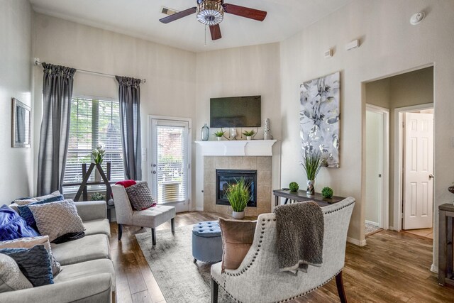 18605 Syndee Loch Ct, Spring, TX 77379 - living area with a ceiling fan, a towering ceiling, wood finished floors, and a tiled fireplace