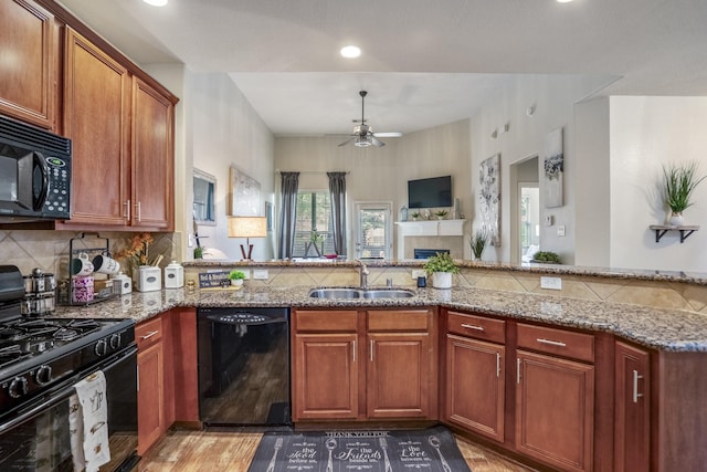 18605 Syndee Loch Ct, Spring, TX 77379 - kitchen with black appliances, a ceiling fan, light stone countertops, a fireplace, and recessed lighting