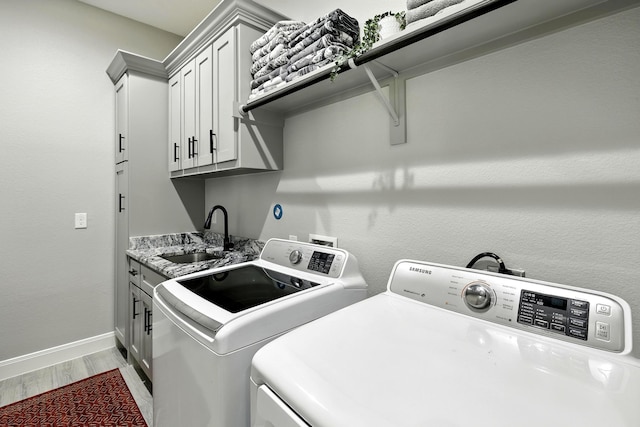 17114 Leon Ct, Splendora, TX 77372 - laundry room featuring separate washer and dryer, light wood-type flooring, and cabinet space