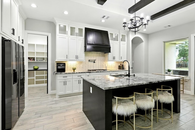 17114 Leon Ct, Splendora, TX 77372 - kitchen featuring stainless steel fridge, a chandelier, recessed lighting, light wood-style floors, and decorative backsplash