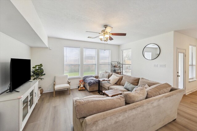 4206 Brazos Bend Dr, Pearland, TX 77584 - living room featuring light wood finished floors, ceiling fan, and a textured ceiling