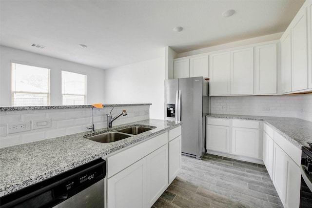22351 Auburn Cabin Ln, Porter, TX 77365 - kitchen featuring stainless steel appliances, tasteful backsplash, and white cabinetry