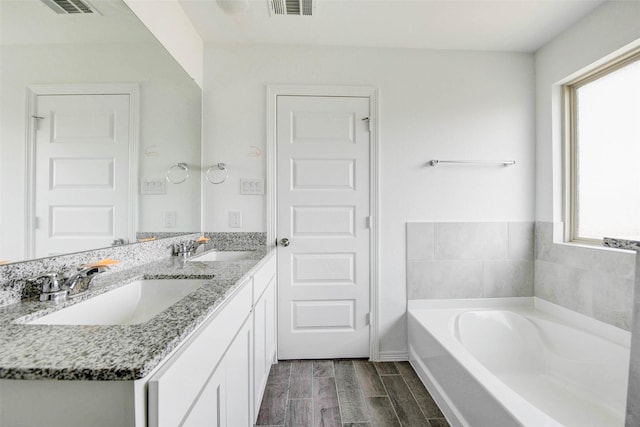 22351 Auburn Cabin Ln, Porter, TX 77365 - bathroom featuring double vanity, a bath, and wood finished floors