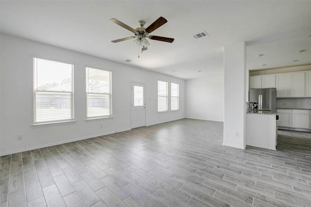 22351 Auburn Cabin Ln, Porter, TX 77365 - unfurnished living room with ceiling fan and light wood finished floors