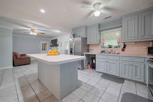 13351 Oak Leaf Ln, Houston, TX 77015 - kitchen featuring ceiling fan, a textured ceiling, appliances with stainless steel finishes, light countertops, and gray cabinetry