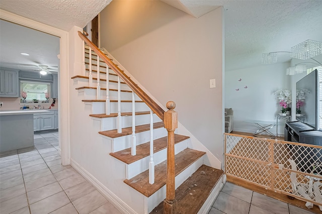 13351 Oak Leaf Ln, Houston, TX 77015 - stairway with tile patterned floors, a textured ceiling, and a ceiling fan