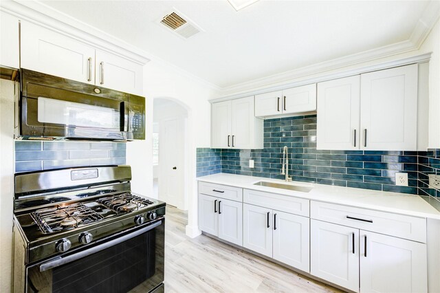 5326 Keystone St, Houston, TX 77021 - kitchen with black appliances, ornamental molding, arched walkways, light countertops, and decorative backsplash