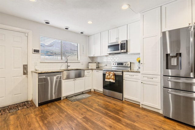 6401 Deihl Rd Unit 1401, Houston, TX 77092 - kitchen featuring stainless steel appliances, light stone countertops, white cabinetry, decorative backsplash, and recessed lighting
