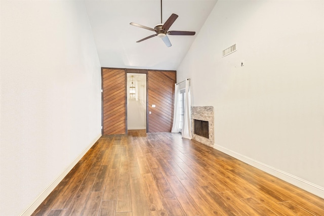 6401 Deihl Rd Unit 1401, Houston, TX 77092 - unfurnished living room featuring high vaulted ceiling, ceiling fan, wood finished floors, a fireplace, and wooden walls