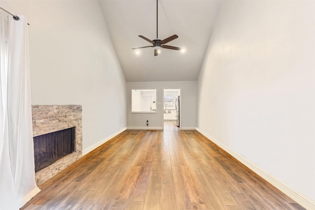 6401 Deihl Rd Unit 1401, Houston, TX 77092 - unfurnished living room featuring a ceiling fan, a stone fireplace, wood finished floors, and high vaulted ceiling