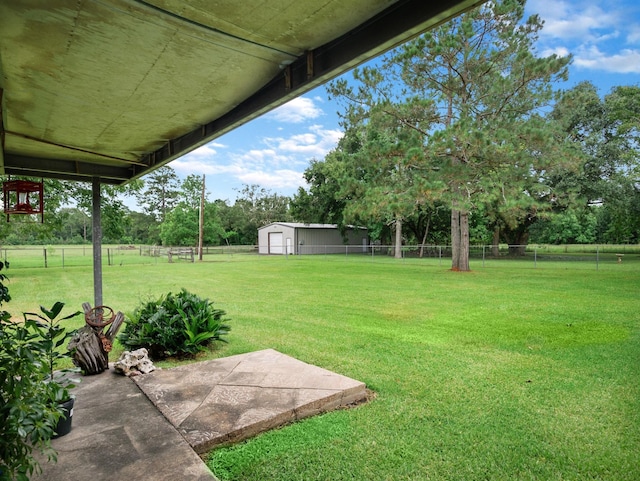 413 Christensen Rd, Hankamer, TX 77560 - fenced backyard with a patio area, a storage shed, and view of scattered trees