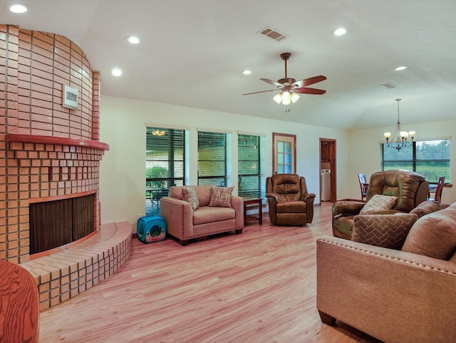 413 Christensen Rd, Hankamer, TX 77560 - living room with lofted ceiling, a brick fireplace, wood finished floors, a chandelier, and a ceiling fan