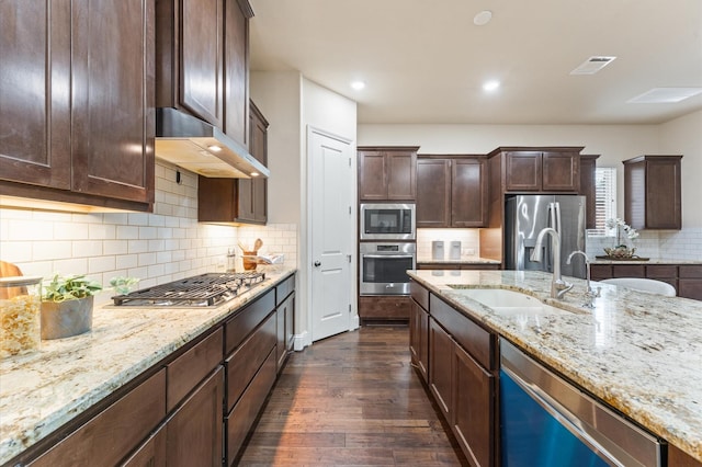 13207 Parkway Meadows Dr, Houston, TX 77077 - kitchen with stainless steel appliances, dark wood-type flooring, wall chimney exhaust hood, light stone counters, and recessed lighting