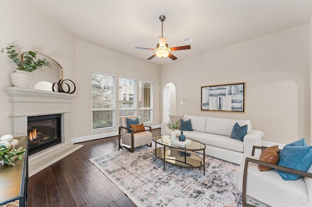 13207 Parkway Meadows Dr, Houston, TX 77077 - living room featuring arched walkways, ceiling fan, a glass covered fireplace, and dark wood-style floors