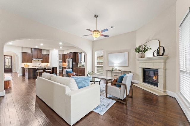13207 Parkway Meadows Dr, Houston, TX 77077 - living area featuring arched walkways, a ceiling fan, a glass covered fireplace, dark wood-style floors, and recessed lighting