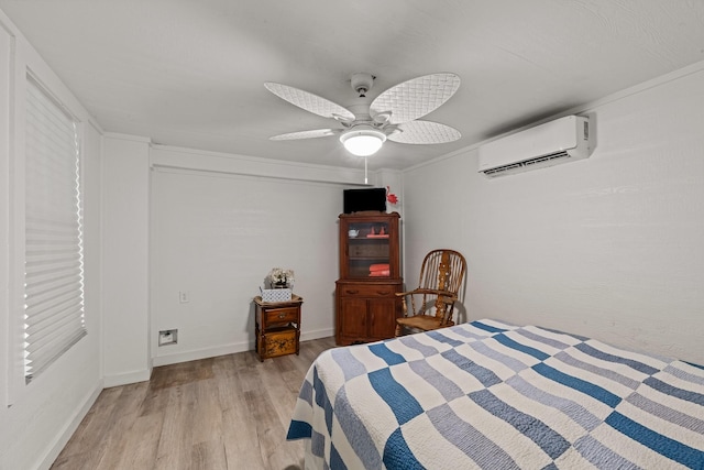 106 E Madison Ave, Port O Connor, TX 77982 - bedroom with a wall mounted air conditioner, light wood-style floors, and a ceiling fan