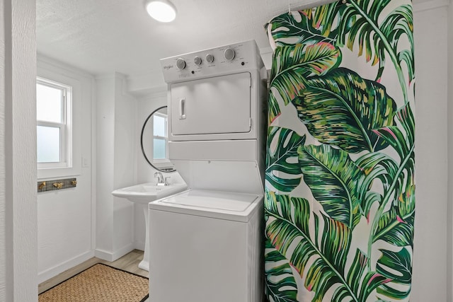 106 E Madison Ave, Port O Connor, TX 77982 - laundry room with stacked washing machine and dryer and light wood-style flooring