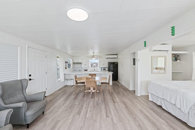 106 E Madison Ave, Port O Connor, TX 77982 - living area featuring light wood finished floors, ceiling fan, and a wall unit AC