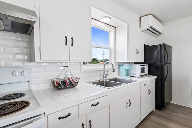106 E Madison Ave, Port O Connor, TX 77982 - kitchen with white appliances, ventilation hood, a wall mounted AC, tasteful backsplash, and white cabinets