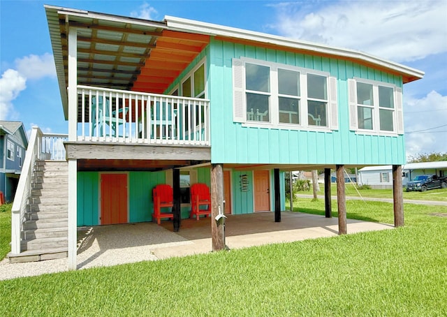 106 E Madison Ave, Port O Connor, TX 77982 - rear view of house with a patio area, a lawn, stairway, a carport, and a wooden deck