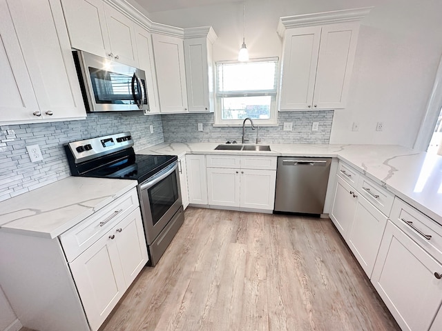 344 Thunder Rd, Surfside Beach, TX 77541 - kitchen featuring appliances with stainless steel finishes, light wood-type flooring, white cabinetry, and tasteful backsplash