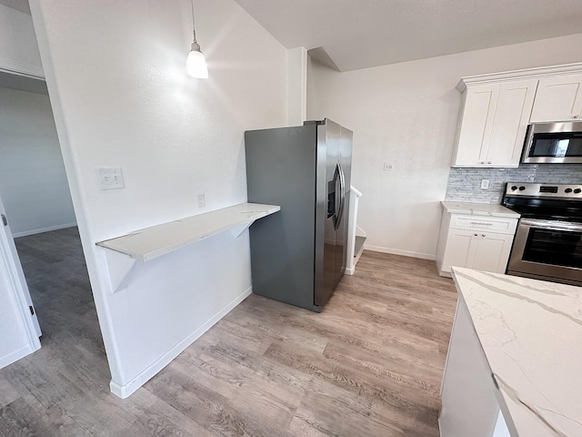344 Thunder Rd, Surfside Beach, TX 77541 - kitchen with appliances with stainless steel finishes, light wood-style floors, light stone counters, and backsplash