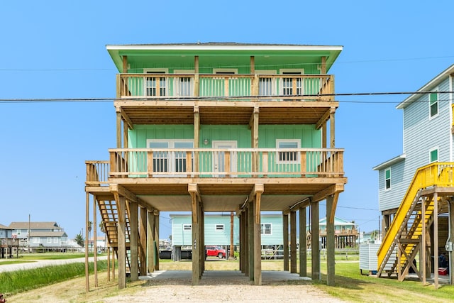 344 Thunder Rd, Surfside Beach, TX 77541 - raised beach house featuring stairway, a carport, board and batten siding, and a wooden deck