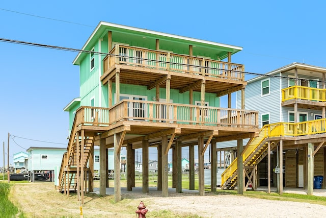344 Thunder Rd, Surfside Beach, TX 77541 - rear view of property with board and batten siding, stairs, a wooden deck, and a carport