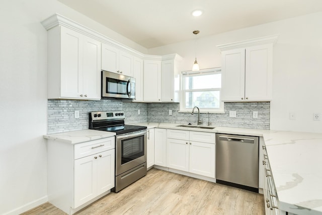 344 Thunder Rd, Surfside Beach, TX 77541 - kitchen with stainless steel appliances, light wood-style floors, white cabinetry, backsplash, and recessed lighting