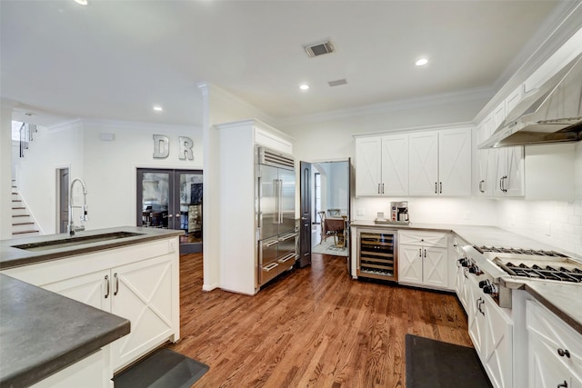 4004 Childress St, Houston, TX 77005 - kitchen with wine cooler, appliances with stainless steel finishes, french doors, crown molding, and wall chimney range hood