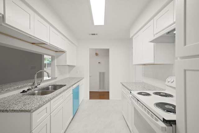2531 Anzalone Dr, Spring, TX 77373 - kitchen with white electric range, dishwashing machine, white cabinets, light stone counters, and custom range hood