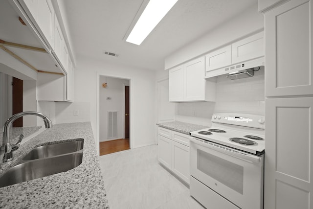 2531 Anzalone Dr, Spring, TX 77373 - kitchen with white electric stove, under cabinet range hood, white cabinetry, and light stone countertops