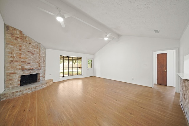 2531 Anzalone Dr, Spring, TX 77373 - unfurnished living room with ceiling fan, light wood finished floors, a brick fireplace, and a textured ceiling