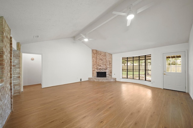 2531 Anzalone Dr, Spring, TX 77373 - unfurnished living room featuring a ceiling fan, wood finished floors, a brick fireplace, track lighting, and a textured ceiling