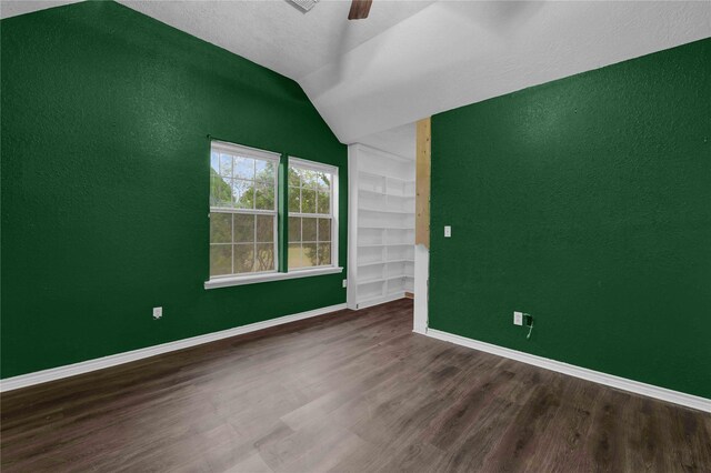 10802 4th 1/2 St, Santa Fe, TX 77510 - empty room with built in shelves, ceiling fan, wood finished floors, vaulted ceiling, and a textured wall