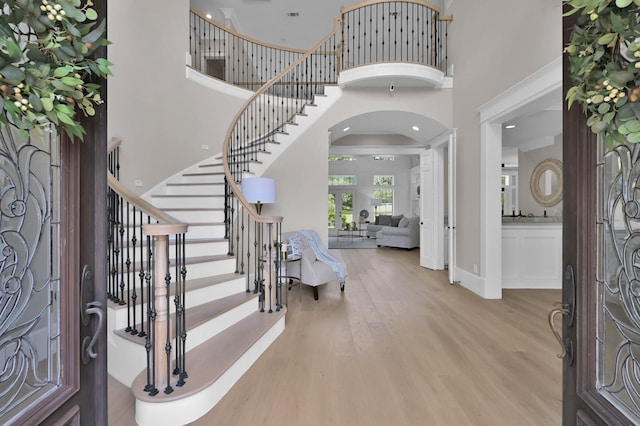 15203 Wildwood Cir, Magnolia, TX 77354 - entrance foyer with arched walkways, wood finished floors, a high ceiling, and stairs