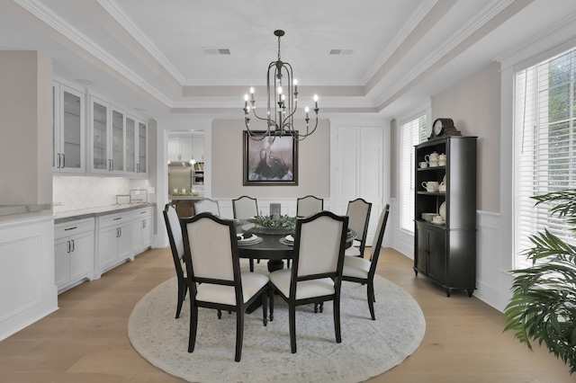 15203 Wildwood Cir, Magnolia, TX 77354 - dining area with a chandelier, a tray ceiling, plenty of natural light, a wainscoted wall, and ornamental molding