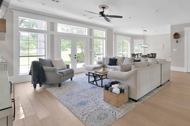 15203 Wildwood Cir, Magnolia, TX 77354 - living room featuring ornamental molding, light wood finished floors, ceiling fan, and french doors