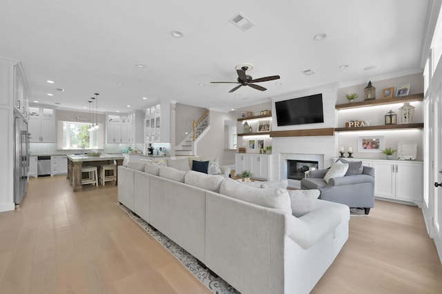 15203 Wildwood Cir, Magnolia, TX 77354 - living area featuring ceiling fan, a fireplace, recessed lighting, light wood-type flooring, and stairs