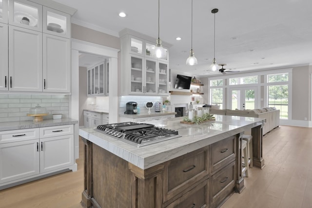 15203 Wildwood Cir, Magnolia, TX 77354 - kitchen with stainless steel gas stovetop, a ceiling fan, white cabinets, a fireplace, and recessed lighting