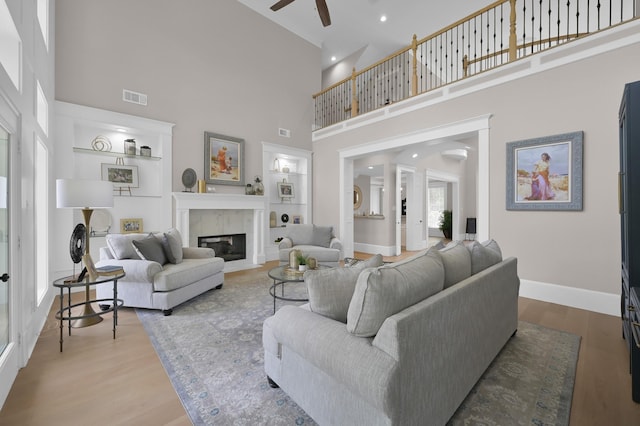 15203 Wildwood Cir, Magnolia, TX 77354 - living area featuring ceiling fan, a towering ceiling, wood finished floors, and a fireplace