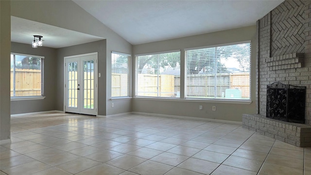 3018 Sherborne St, Pearland, TX 77584 - unfurnished living room with light tile patterned flooring, lofted ceiling, a brick fireplace, and french doors