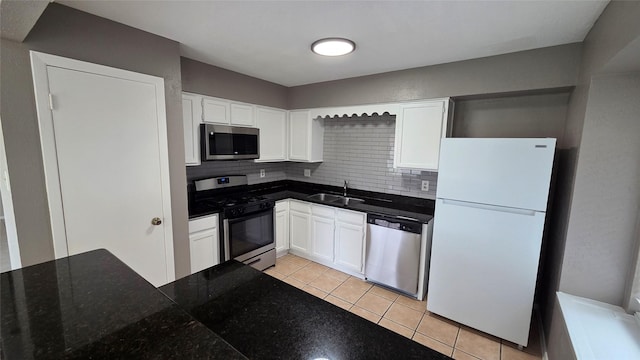 3018 Sherborne St, Pearland, TX 77584 - kitchen featuring appliances with stainless steel finishes, light tile patterned floors, decorative backsplash, and white cabinetry