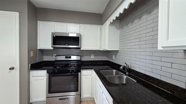 3018 Sherborne St, Pearland, TX 77584 - kitchen featuring appliances with stainless steel finishes, decorative backsplash, white cabinetry, and dark stone countertops