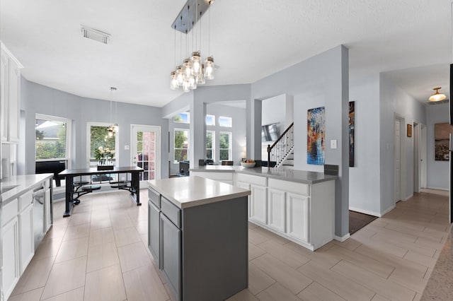 4807 Louisa Ct, Sugar Land, TX 77478 - kitchen featuring white cabinets, a kitchen island, decorative light fixtures, light countertops, and a chandelier