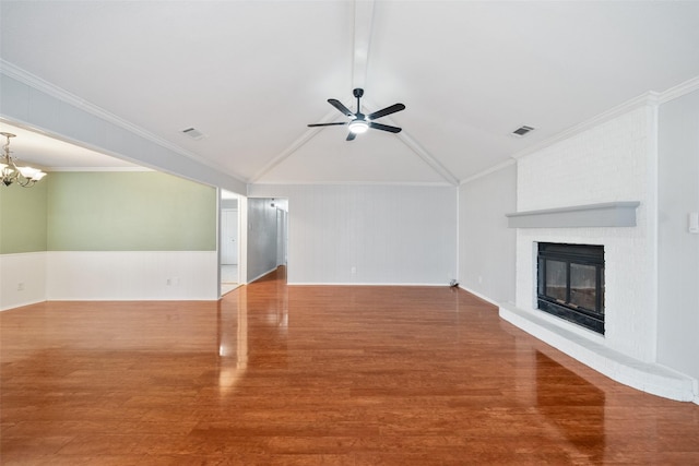 12417 Pegasus Dr, Willis, TX 77318 - unfurnished living room with wood finished floors, a ceiling fan, a brick fireplace, a chandelier, and a wainscoted wall