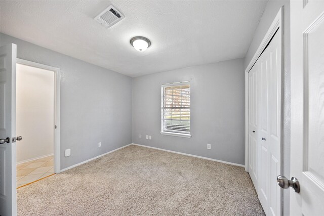 12417 Pegasus Dr, Willis, TX 77318 - unfurnished bedroom featuring carpet, a closet, and a textured ceiling