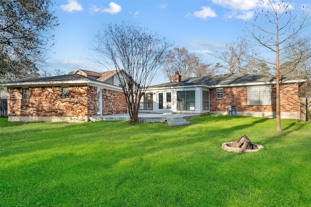 12417 Pegasus Dr, Willis, TX 77318 - rear view of house featuring a fire pit, a yard, brick siding, and a chimney