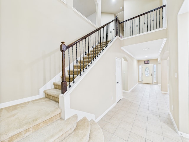 16911 Wortley Dr, Houston, TX 77084 - stairs featuring a high ceiling, tile patterned floors, and arched walkways