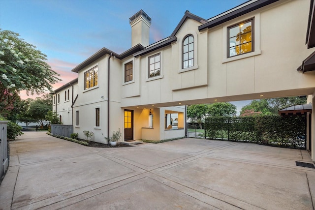 1039 Kirby Dr, Houston, TX 77019 - view of front of house featuring driveway, a chimney, a carport, and stucco siding